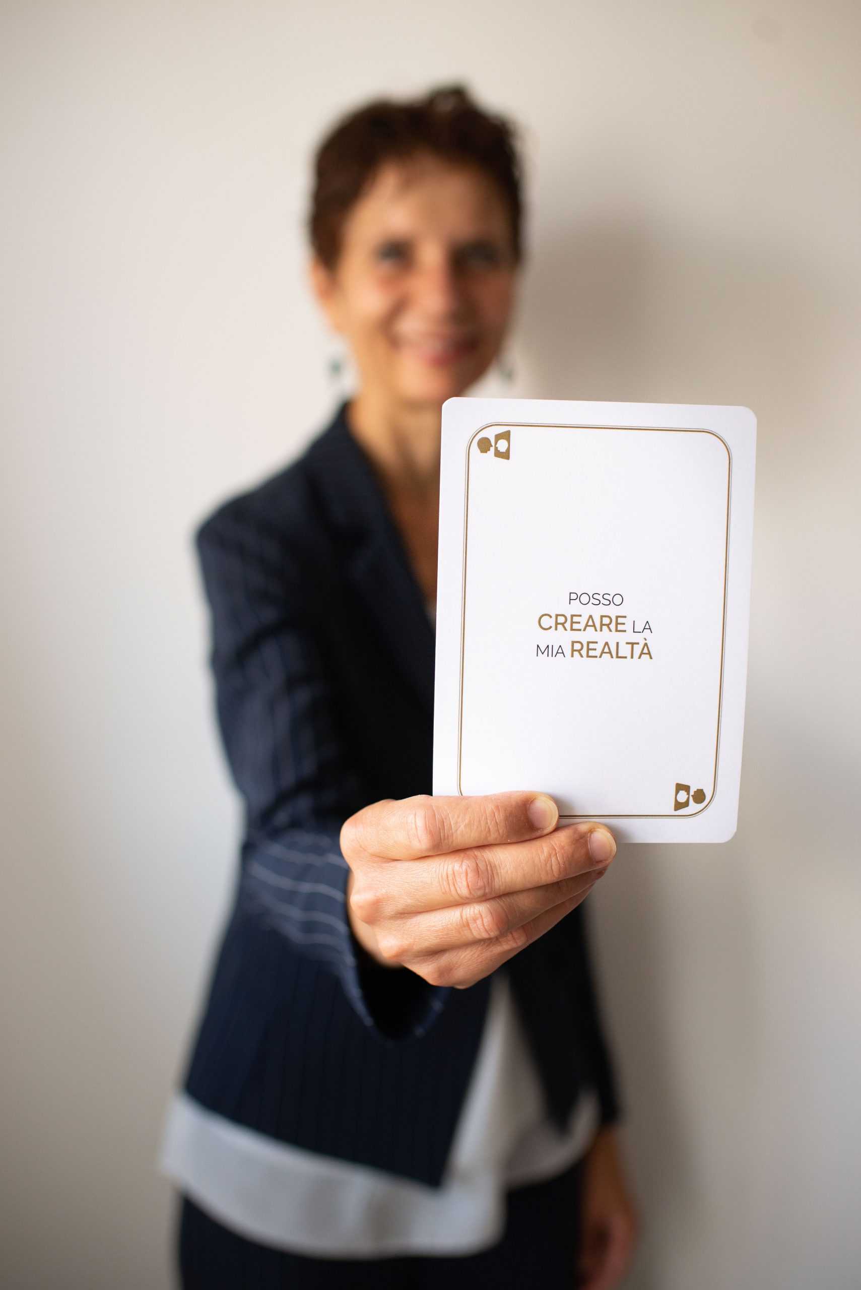 Barbara Chiavarino tiene in mano una carta motivazionale con il messaggio 'Posso creare la mia realtà', parte dei progetti The Project Player e Back to the Under Planet